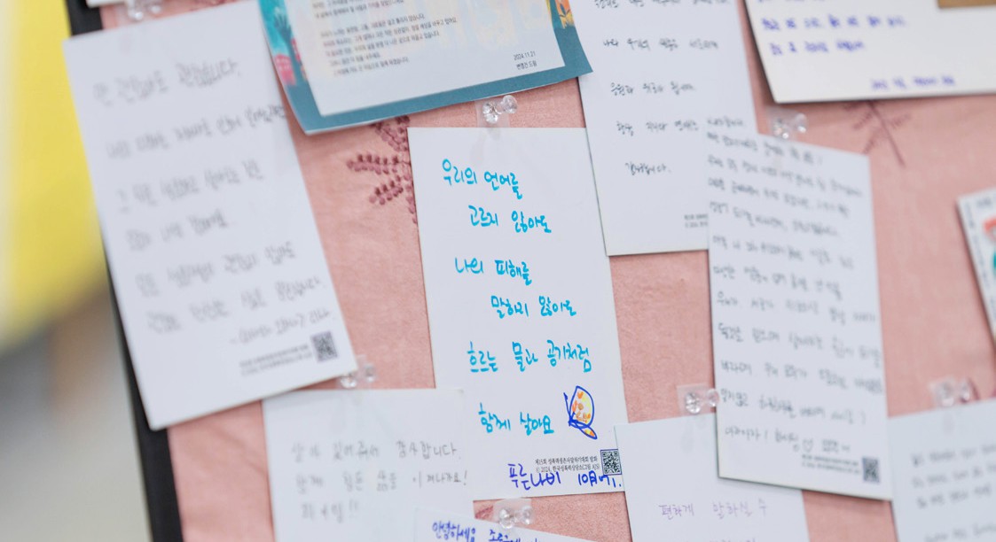 분홍빛 게시판에 응답이들이 손글씨로 적은 다양한 색의 메시지 카드들이 겹겹이 붙어 있는 모습