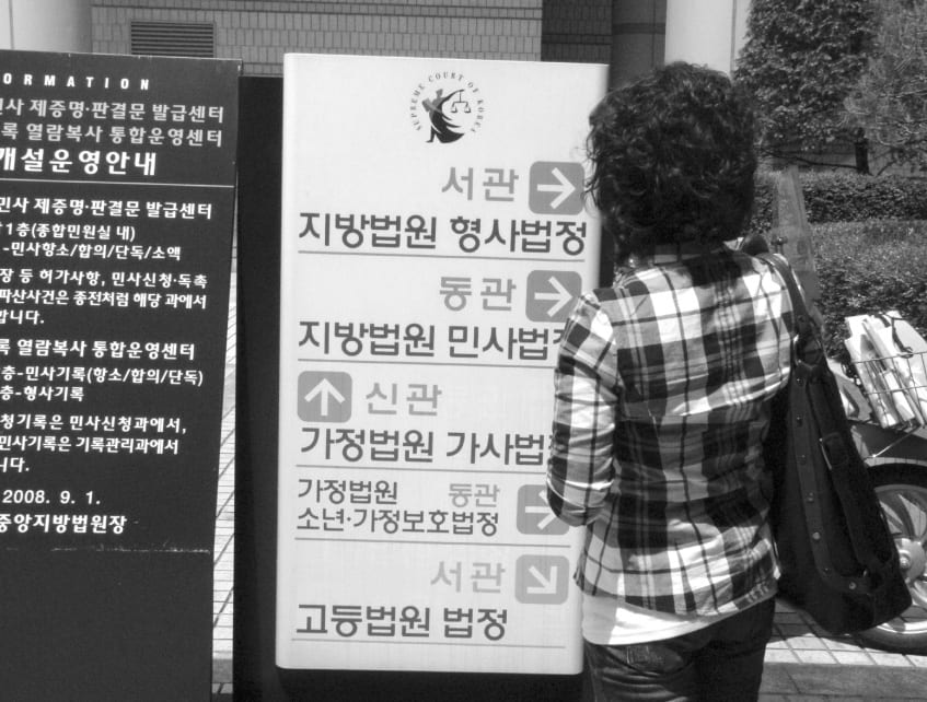 법원 시설 안내판을 보고 있는 사람