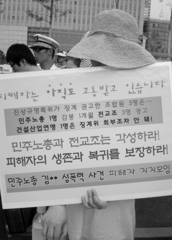 ‘피해자는 아직도 고통받고 있습니다’ 피켓을 든 참가자